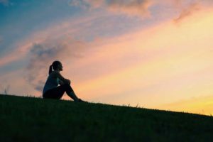 Woman pondering the sunset for the key to a meaningful life in retirement