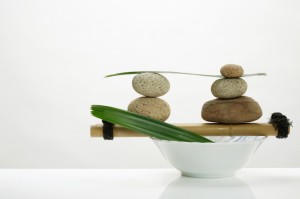 Two sets of stacked stones on a stick on a bowl, representing balance