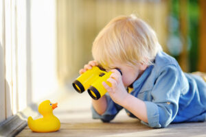 Child playing with binoculars for why don't employees change their behavior