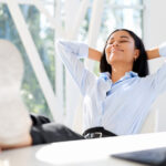 Woman kicking back at desk for stress resilience 