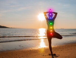 Woman with chakras on sunset beach for balancing chakras reveals your best healing path