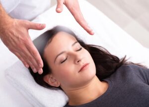 Young woman receiving a Reiki healing session 