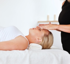 Woman on a table receiving Reiki healing energy