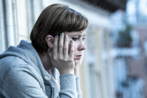 Depressed looking young woman for signs of negative energy in a person